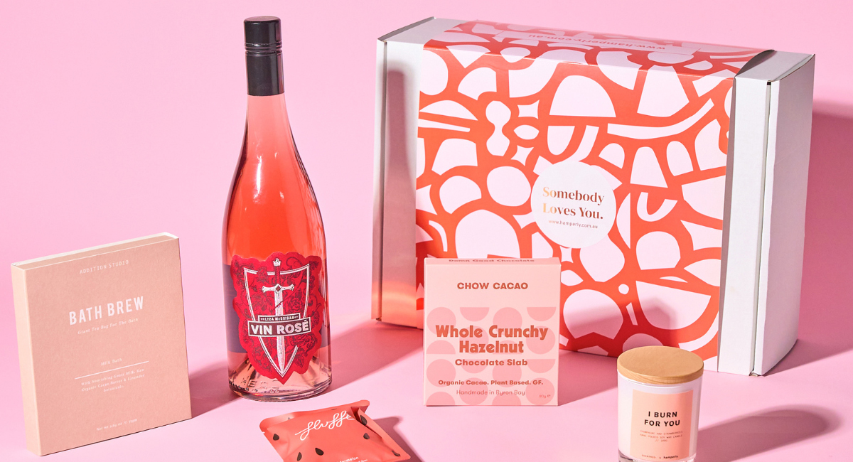 A pink box with a bold, abstract design and the text "Somebody Loves You" printed on it