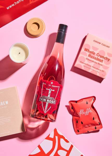 Bottle of wine and box of chocolate and glass candle