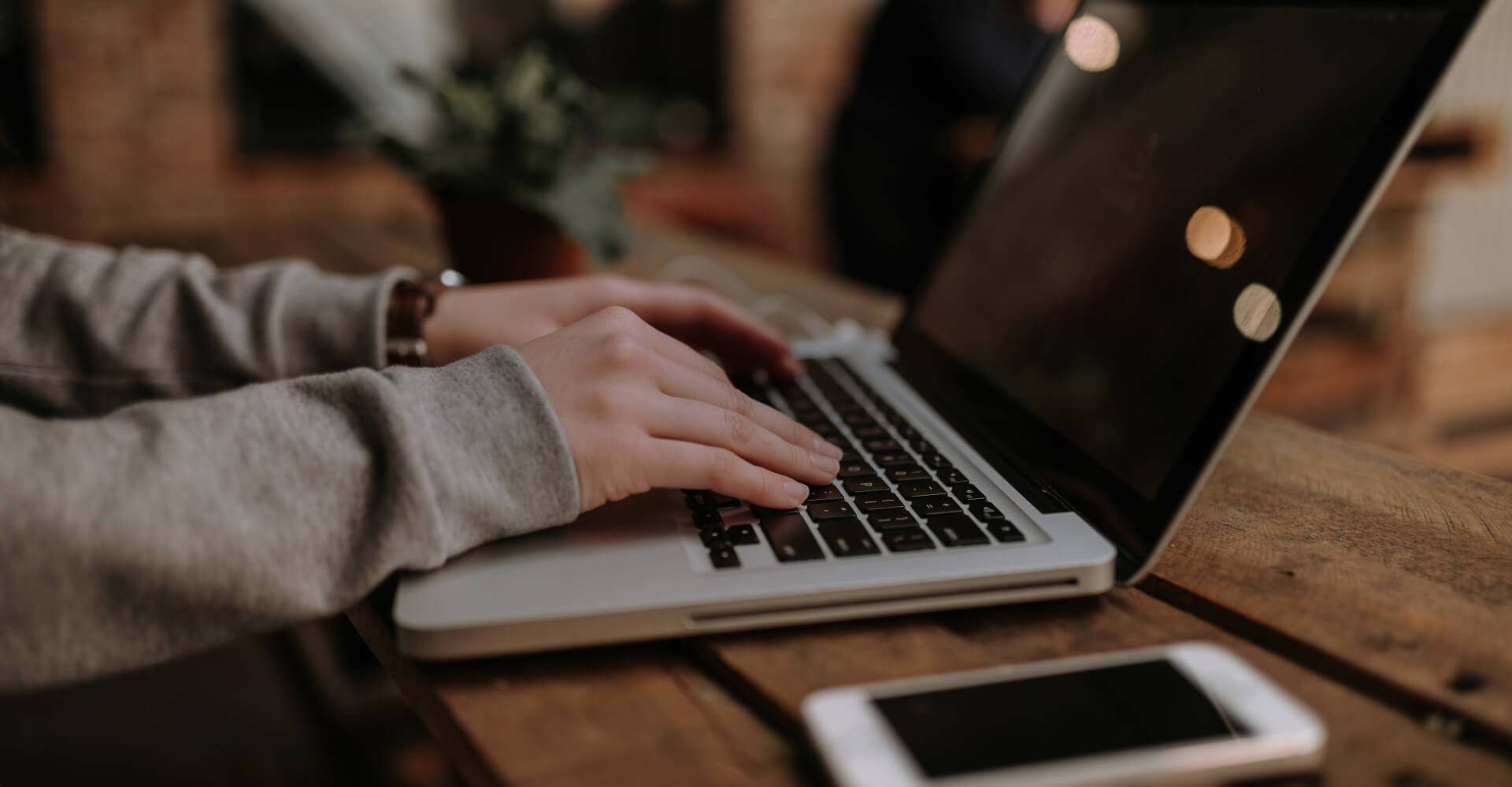 Hands typing on laptop keyboard
