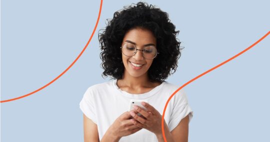 Image of woman wearing a white shirt busy looking at her mobile phone