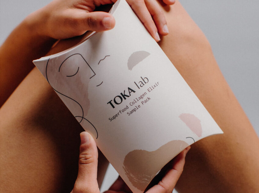 Close-up picture of a person holding a white package labeled 'TOKA lab'