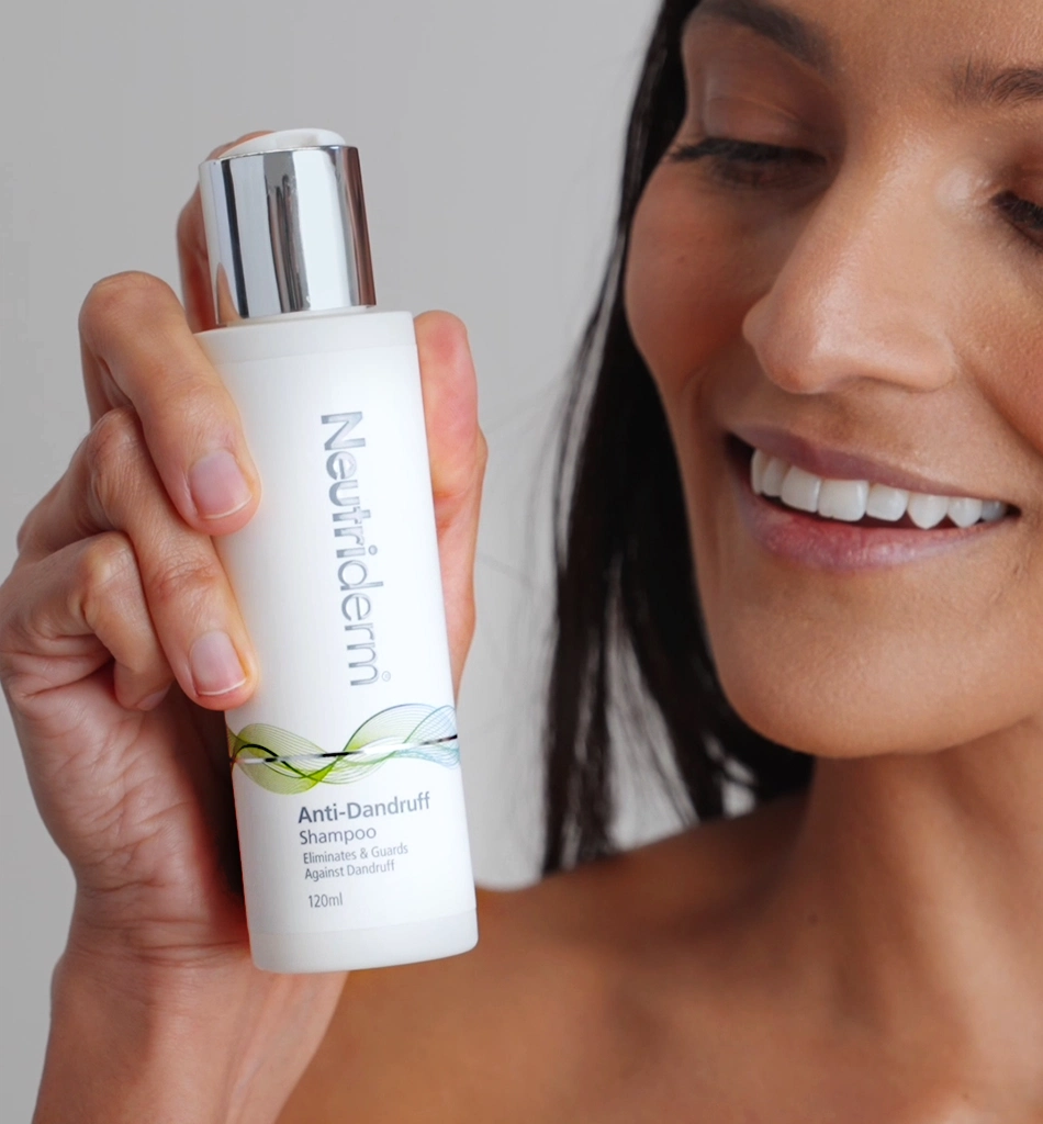 A Woman Holding a 120ml Bottle of Neutriderm Anti-Dandruff Shampoo