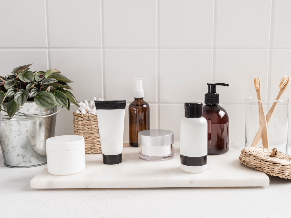 Different Cosmetic Bottles placed on a white tile background